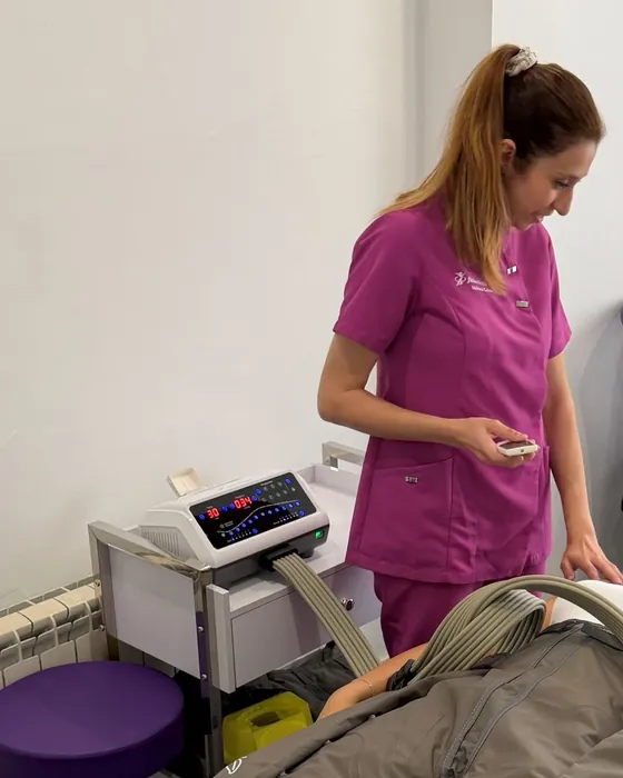 Mónica Gómez junto a la camilla durante una sesión de presoterapia, con el aparato al lado