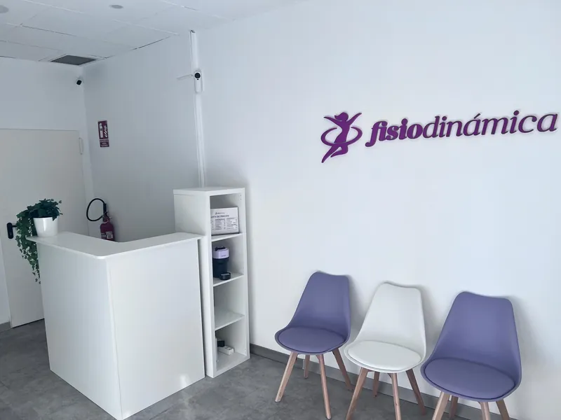 La recepción de Fisiodinámica, con el logo en la pared y las sillas de espera