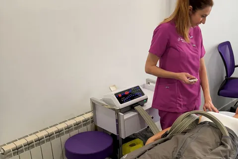Sesión de presoterapia en Fisiodinámica: el aparato y las botas sobre la camilla, con Mónica al lado